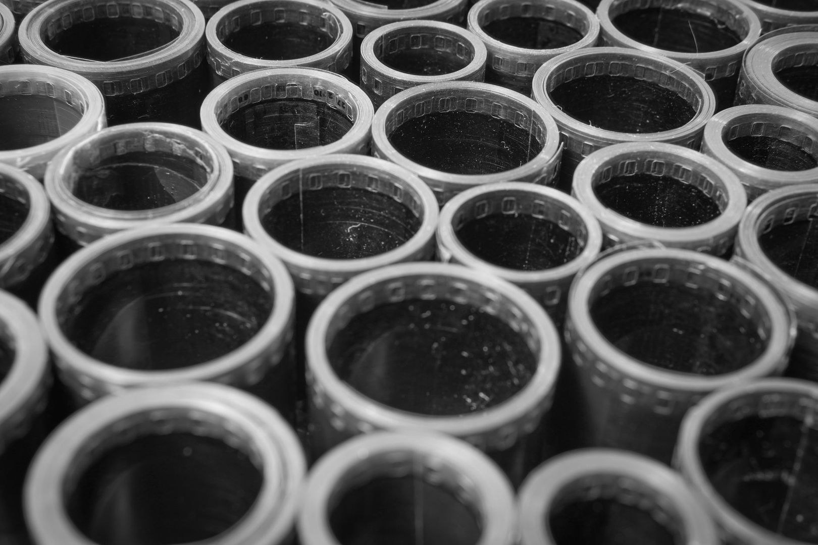 Close-up of overlapping clear plastic line spools in monochrome